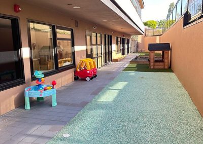 Bright outdoor space with toys and safe flooring for young children at The Learning Circle Childcare.