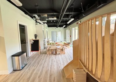 Bright, spacious childcare center with play area and natural lighting.