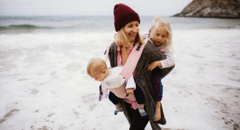 Learning Circle Care. Joyful mother with children on the beach, outdoor childcare experience.