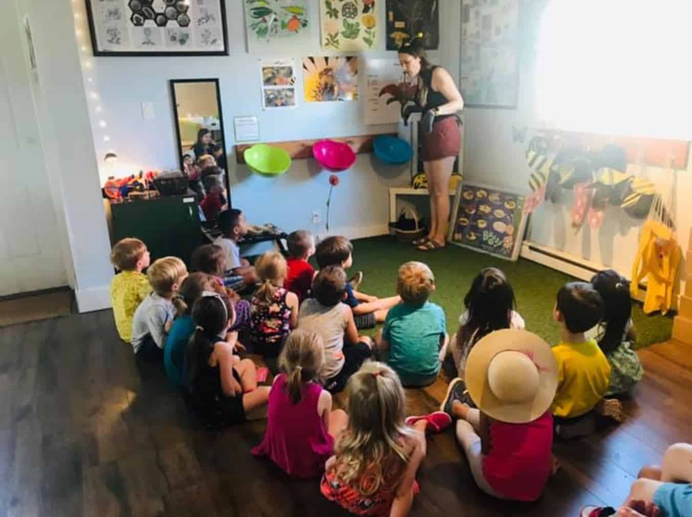 Learning children listening to a storytelling session at The Learning Circle Childcare Centre. Bright, colorful classroom with educational decorations.