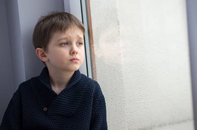 Learning circle child. Young boy looking out the window, thoughtful and reflective.